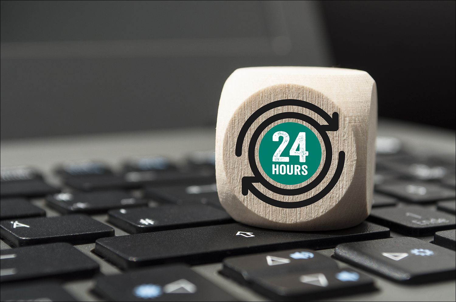 Picture of laptop keyboard with wooden dice showing number 24.